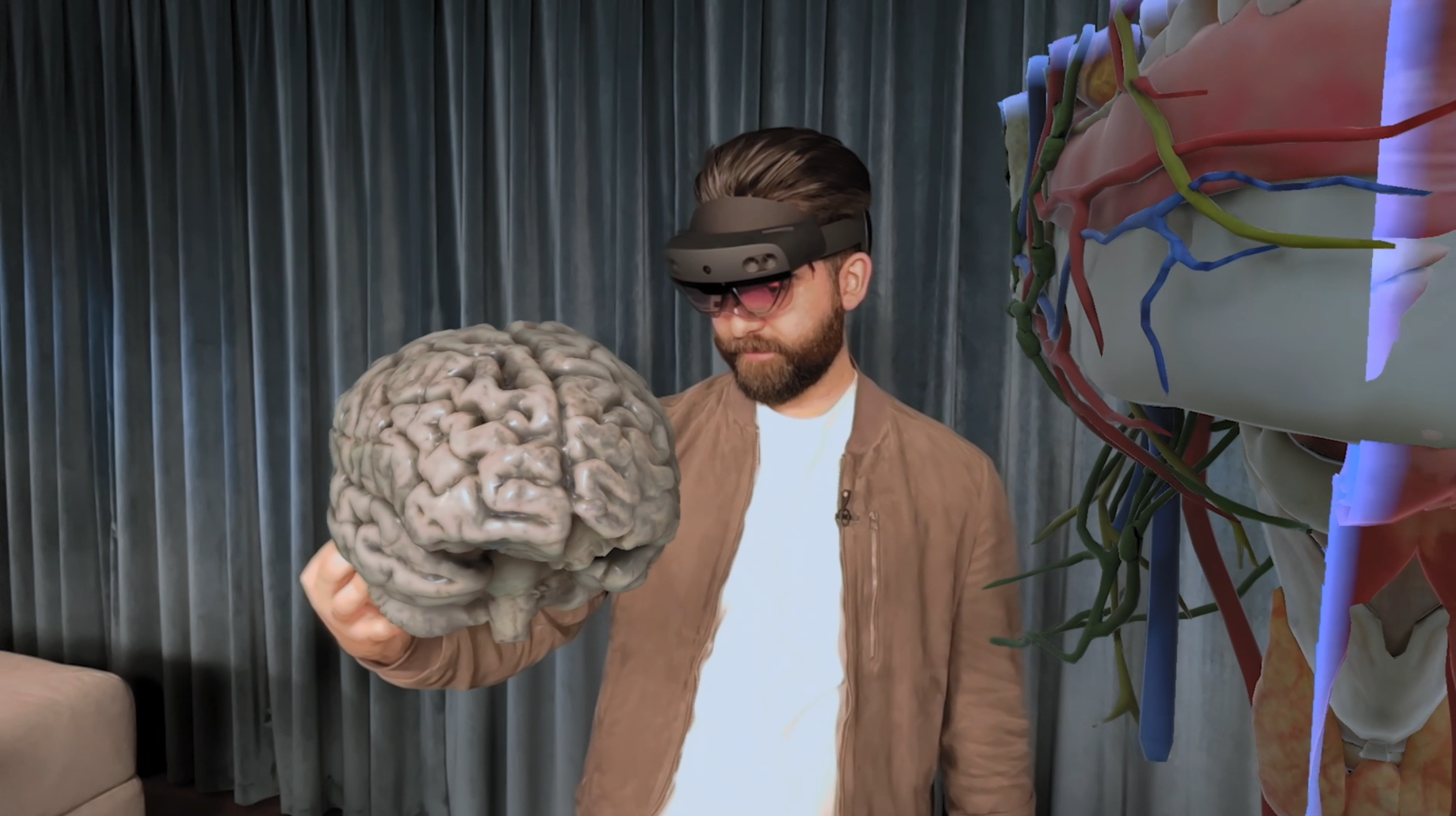Alex Karim using a mixed reality headset while interacting with a 3D brain model